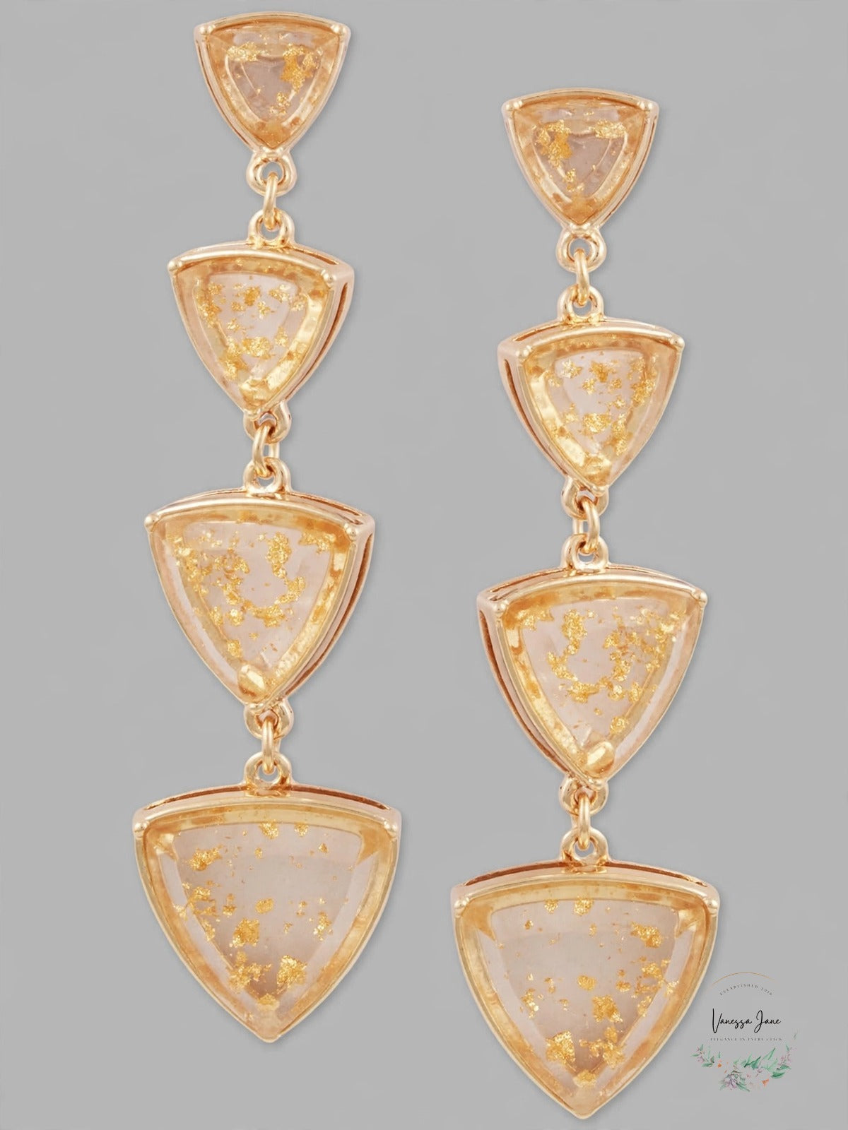 Guess clear gold triangle drop earrings on gray